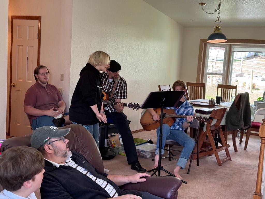 Youth and leaders worshipping with guitars in a living room