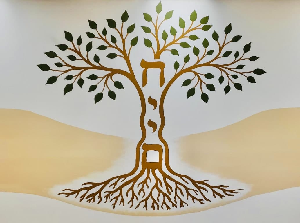 The Talmidei Yeshua tree-and-scroll emblem painted on the wall at our entrance