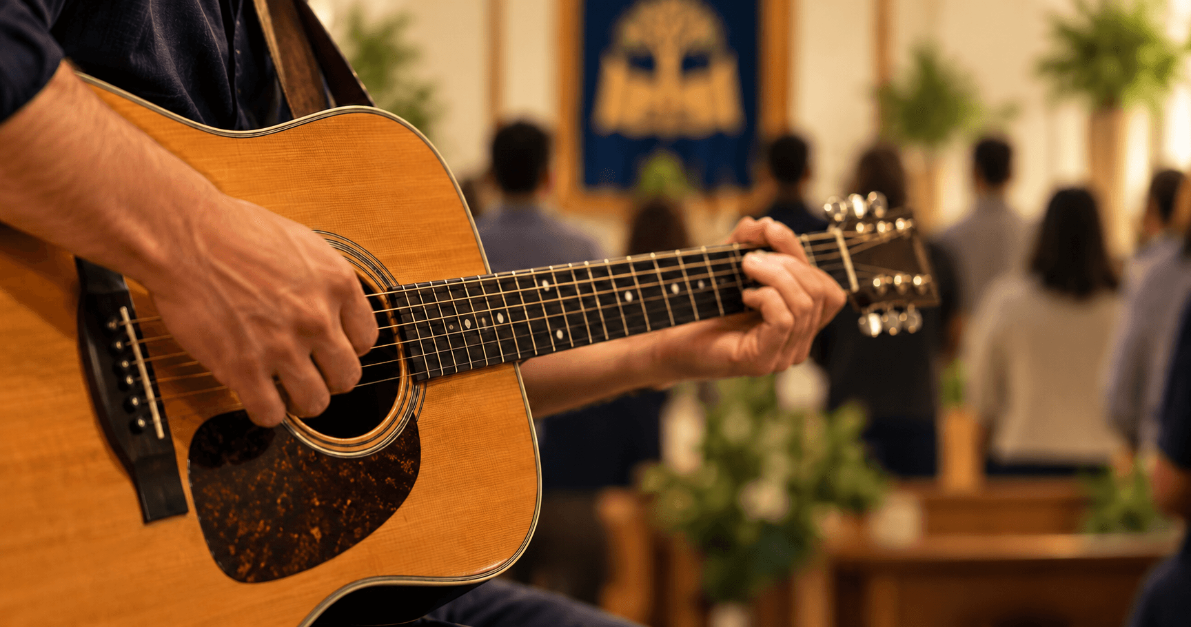 A guitarist leading worship, with the congregation standing before the ark